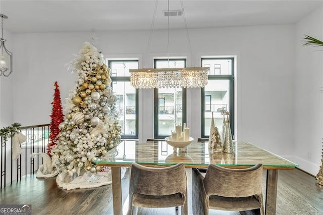 dining area featuring hardwood / wood-style floors and an inviting chandelier