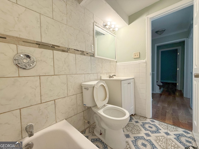 bathroom featuring vanity, toilet, tile walls, and a washtub