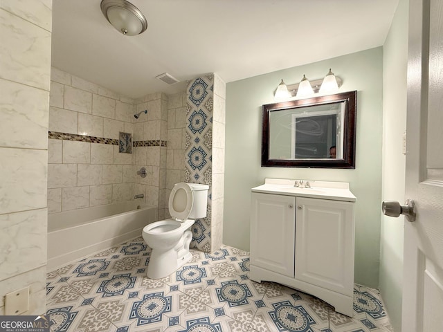 full bathroom featuring vanity, tile patterned floors, toilet, and tiled shower / bath