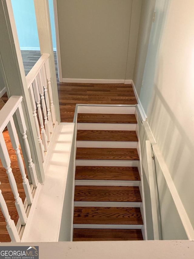 stairway with hardwood / wood-style floors