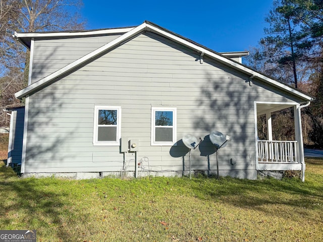 view of property exterior with a lawn and covered porch