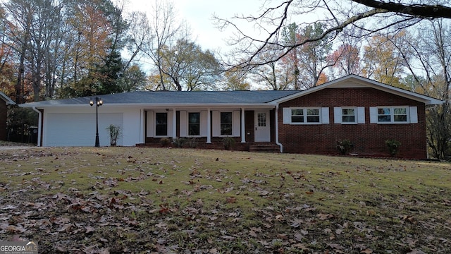 ranch-style house featuring a garage, covered porch, and a front yard