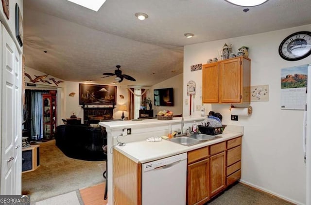 kitchen featuring lofted ceiling, sink, carpet, white dishwasher, and kitchen peninsula