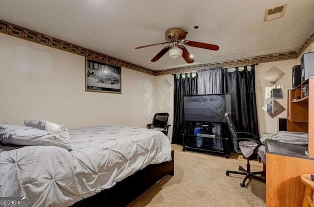 bedroom featuring a textured ceiling, ceiling fan, and carpet