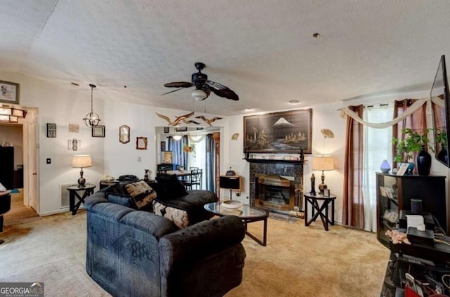 living room featuring ceiling fan, light colored carpet, and a textured ceiling