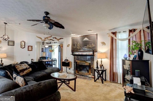 living room with light colored carpet, plenty of natural light, a stone fireplace, and a textured ceiling