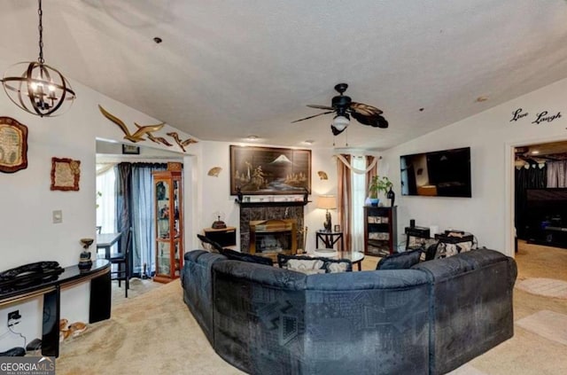 carpeted living room featuring lofted ceiling, a stone fireplace, ceiling fan with notable chandelier, and a textured ceiling