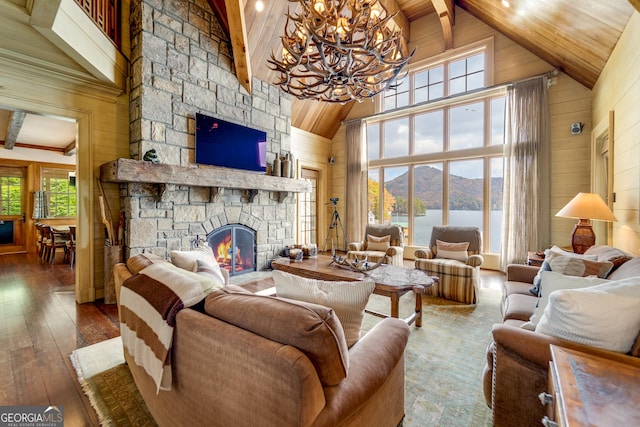 living room featuring dark wood-type flooring, wooden walls, a fireplace, and beam ceiling