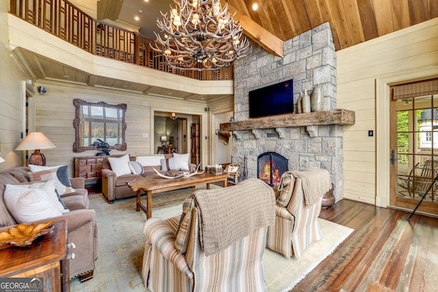 living room featuring high vaulted ceiling, a fireplace, wood-type flooring, wooden ceiling, and wood walls