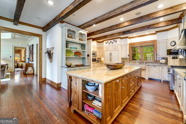 kitchen with dark hardwood / wood-style floors, a center island, stainless steel appliances, light stone countertops, and beam ceiling