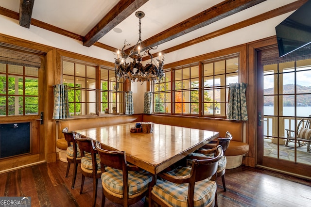 dining room with beamed ceiling, a water view, hardwood / wood-style floors, and an inviting chandelier