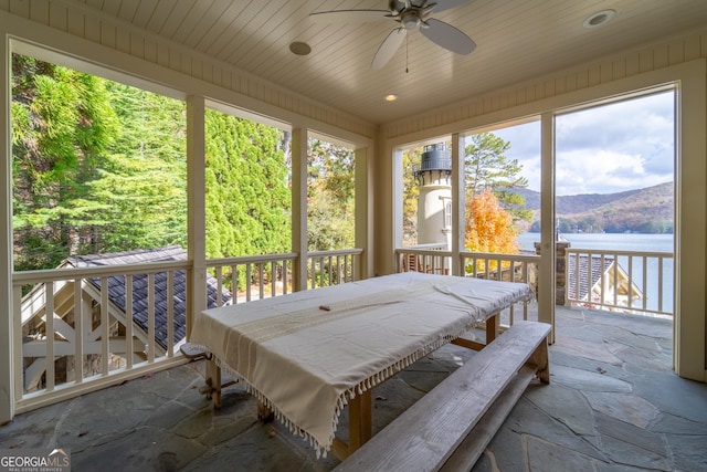 sunroom / solarium with wooden ceiling, ceiling fan, and a water view