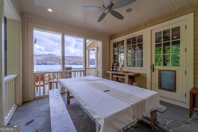 dining room featuring wood ceiling, ceiling fan, and a water and mountain view