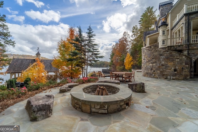 view of patio featuring a water view and a fire pit