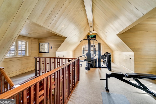 workout room with wood ceiling, vaulted ceiling, light colored carpet, and wooden walls