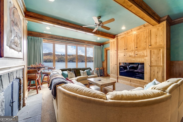 living room featuring ceiling fan, crown molding, beamed ceiling, and a water view