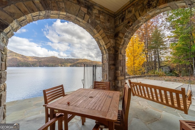 view of dock featuring a patio area and a water and mountain view