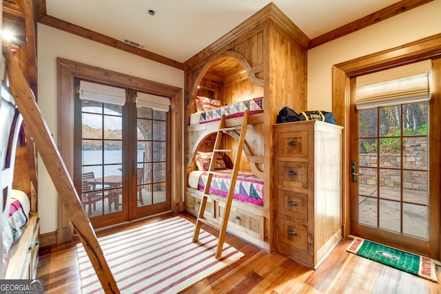 mudroom with a wealth of natural light, light wood-type flooring, and french doors