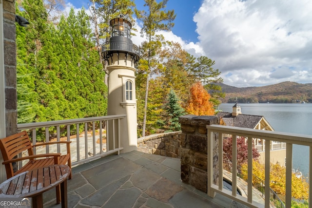 balcony featuring a water and mountain view