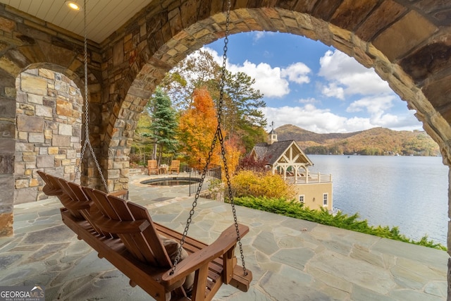 view of patio / terrace featuring a pool and a water and mountain view