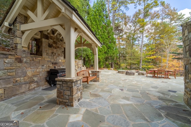 view of patio with grilling area, a gazebo, and a fireplace