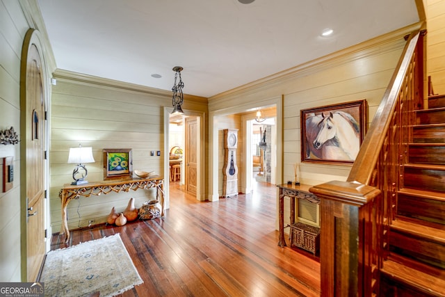 hall with ornamental molding and wood-type flooring