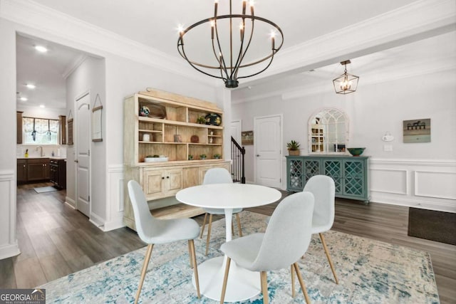 dining space with crown molding, dark hardwood / wood-style floors, sink, and an inviting chandelier