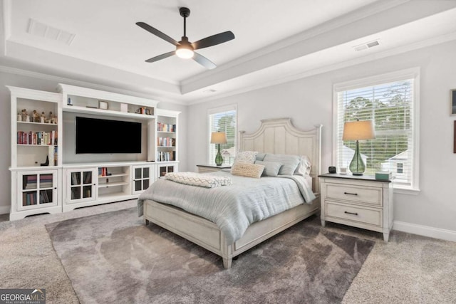 carpeted bedroom featuring crown molding, ceiling fan, and a tray ceiling