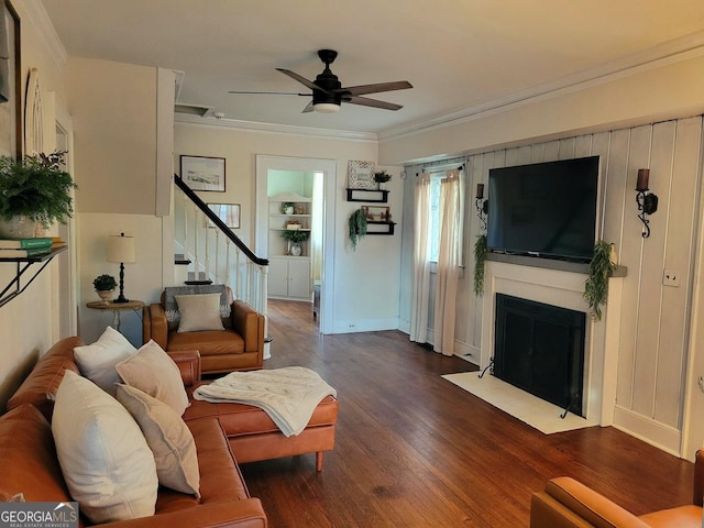 living room featuring ornamental molding, dark wood-type flooring, and ceiling fan