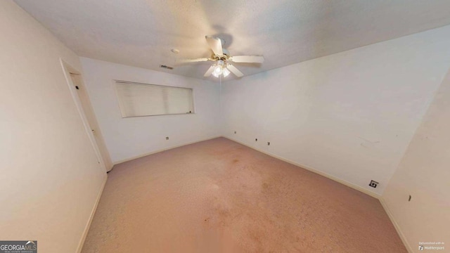 spare room with ceiling fan and light colored carpet