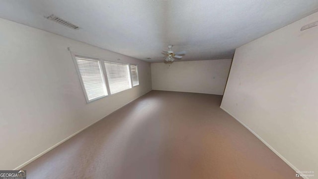 empty room featuring a textured ceiling, concrete floors, and ceiling fan