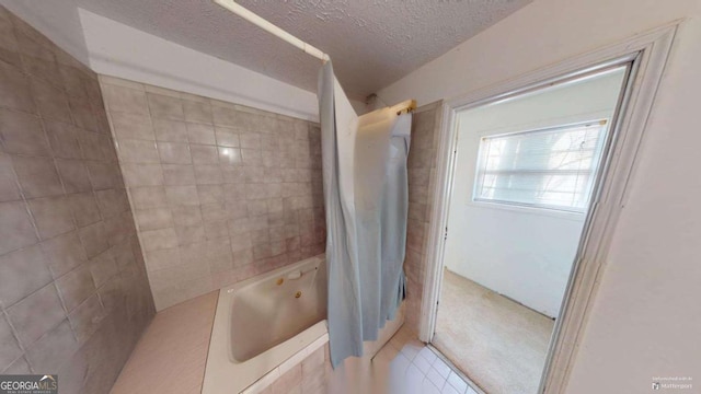 bathroom featuring tiled shower / bath combo, tile patterned flooring, and a textured ceiling