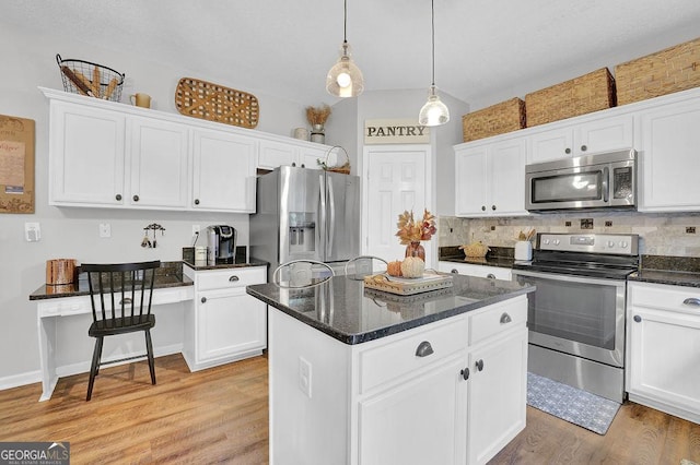 kitchen featuring white cabinetry, decorative light fixtures, light hardwood / wood-style flooring, a kitchen island, and stainless steel appliances