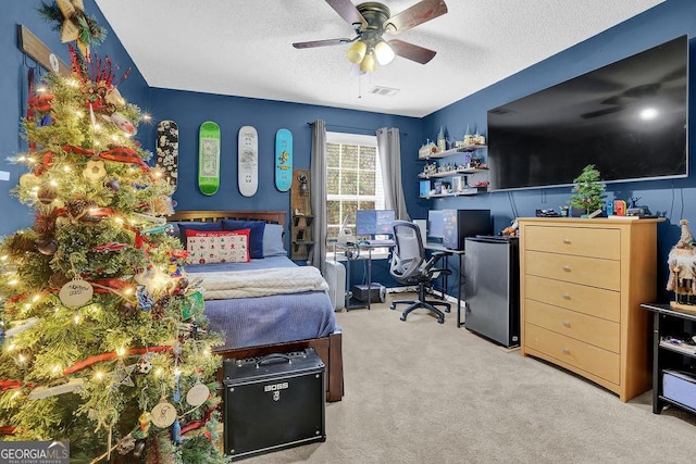 bedroom featuring ceiling fan, carpet floors, and a textured ceiling