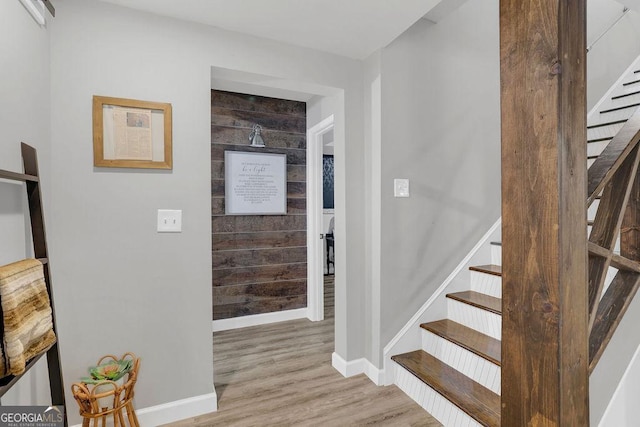 foyer featuring wood walls and light hardwood / wood-style flooring