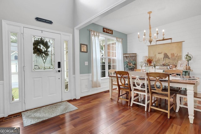 entryway with dark wood-type flooring and a chandelier