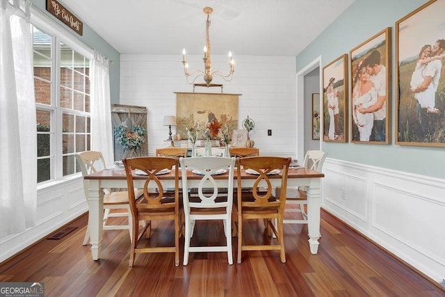 dining room featuring a wealth of natural light, dark wood-type flooring, and a chandelier