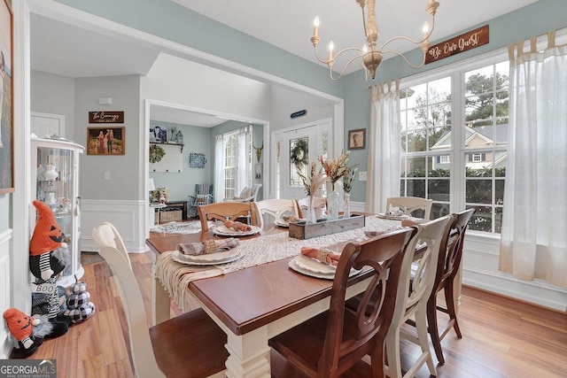 dining area featuring light wood-type flooring and an inviting chandelier