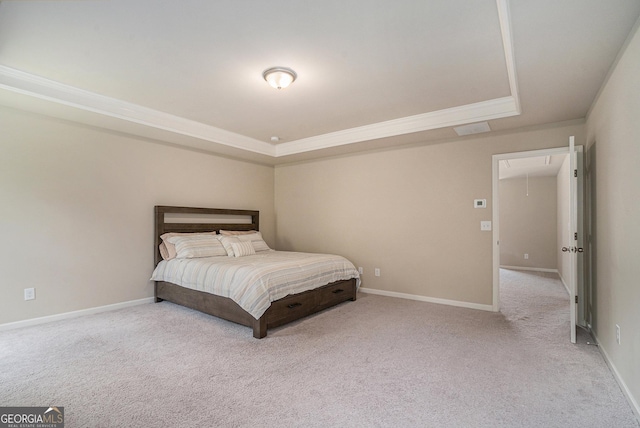 carpeted bedroom featuring crown molding and a tray ceiling