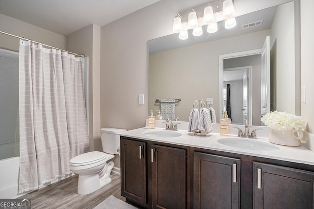 full bathroom with wood-type flooring, toilet, shower / tub combo, and vanity