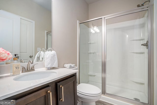 bathroom featuring vanity, toilet, and an enclosed shower