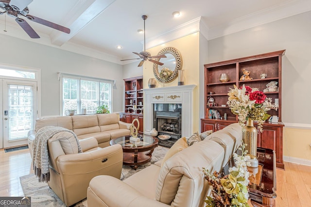 living room featuring ornamental molding, beam ceiling, a high end fireplace, and light hardwood / wood-style flooring