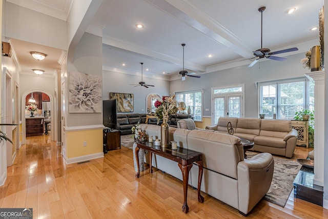 living room featuring ornamental molding, beam ceiling, and light hardwood / wood-style flooring