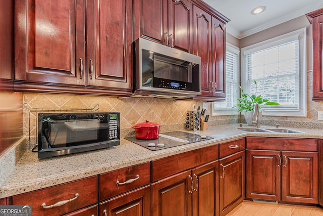 kitchen featuring sink, crown molding, tasteful backsplash, black electric stovetop, and light stone countertops