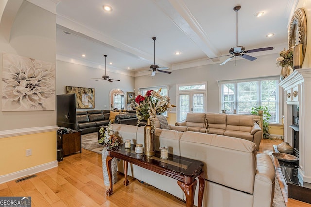 living room featuring crown molding, beam ceiling, and light hardwood / wood-style floors