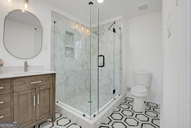 bathroom with vanity, walk in shower, and toilet