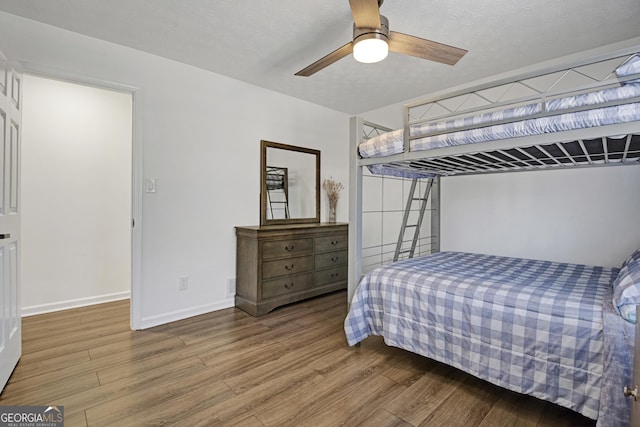 bedroom with wood-type flooring, ceiling fan, and a textured ceiling