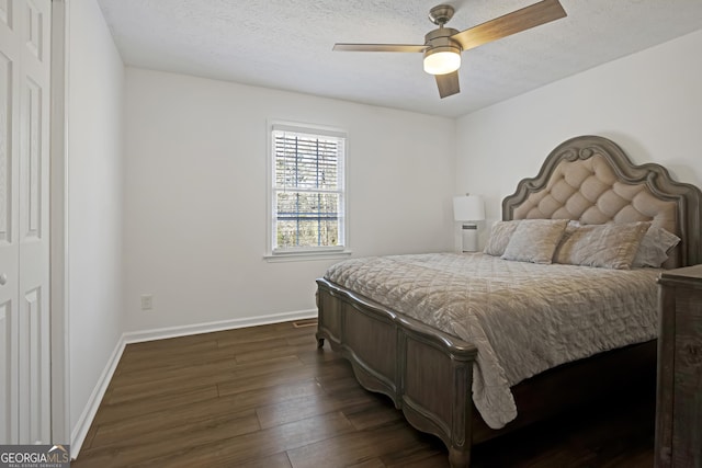 bedroom with ceiling fan, a textured ceiling, and dark hardwood / wood-style flooring