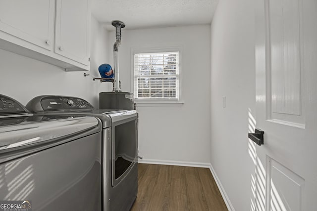 laundry area featuring cabinets, dark hardwood / wood-style floors, a textured ceiling, and independent washer and dryer