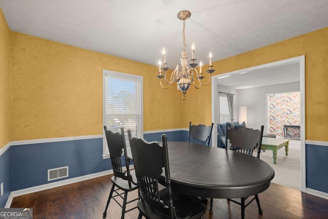 dining space with a notable chandelier, wood-type flooring, and a wealth of natural light